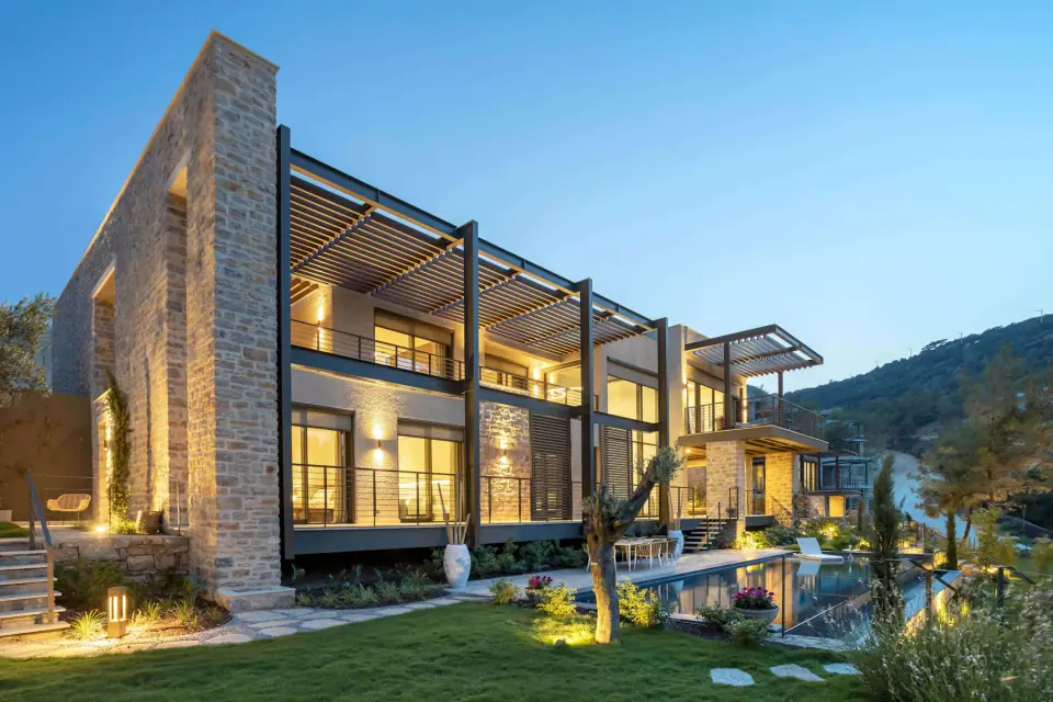 Contemporary stone townhouses lit at dusk (illustrative)